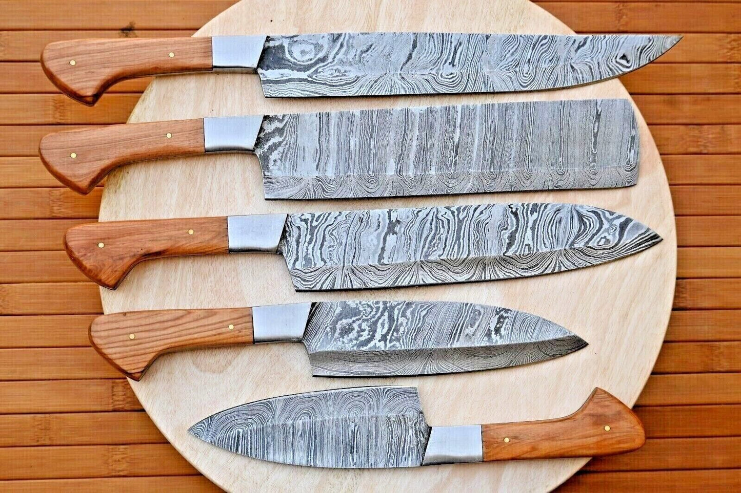 Professional 5 piece handmade Damascus steel chef knife set featuring premium wood handles and reinforced steel bolsters.