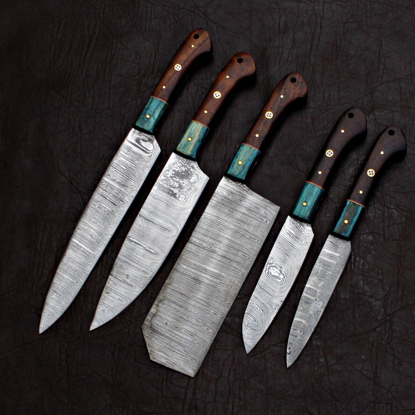 Close up of hand forged Damascus steel pattern on a custom chef kitchen knife with satin polish.