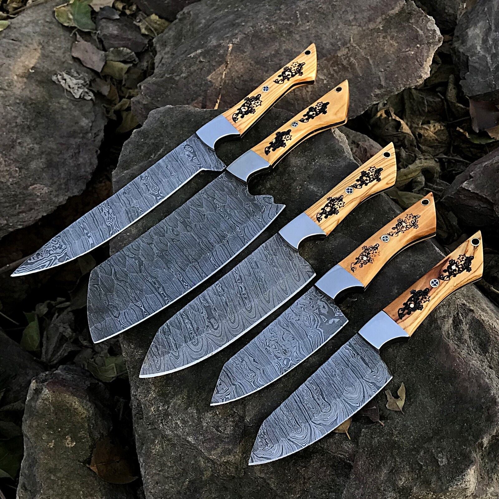 5pc custom handmade Damascus chef knife set featuring forged steel blades and unique ergonomic handles on a rustic wood background.