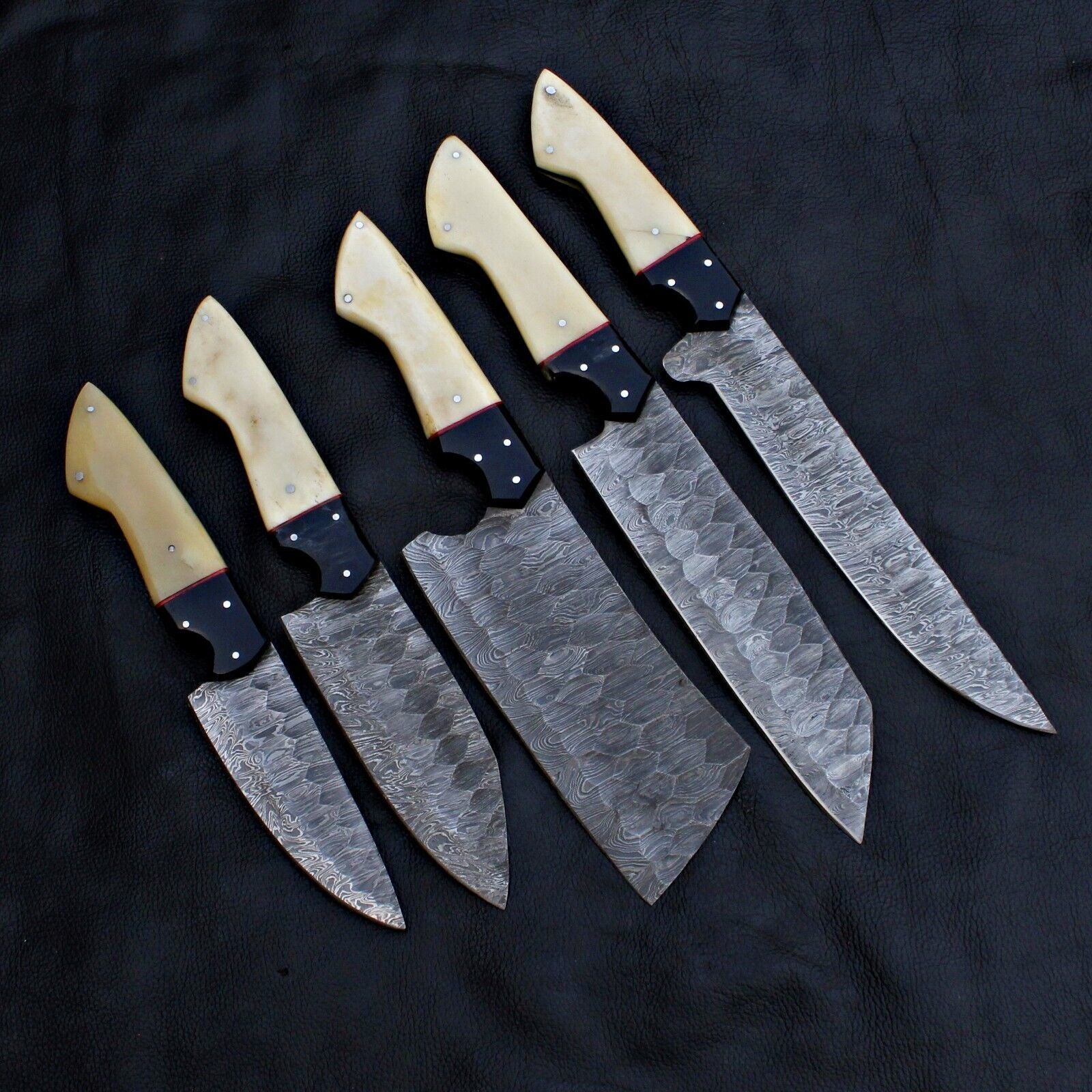 Custom 5 piece Damascus steel kitchen knife set arranged for professional food preparation and culinary tasks.