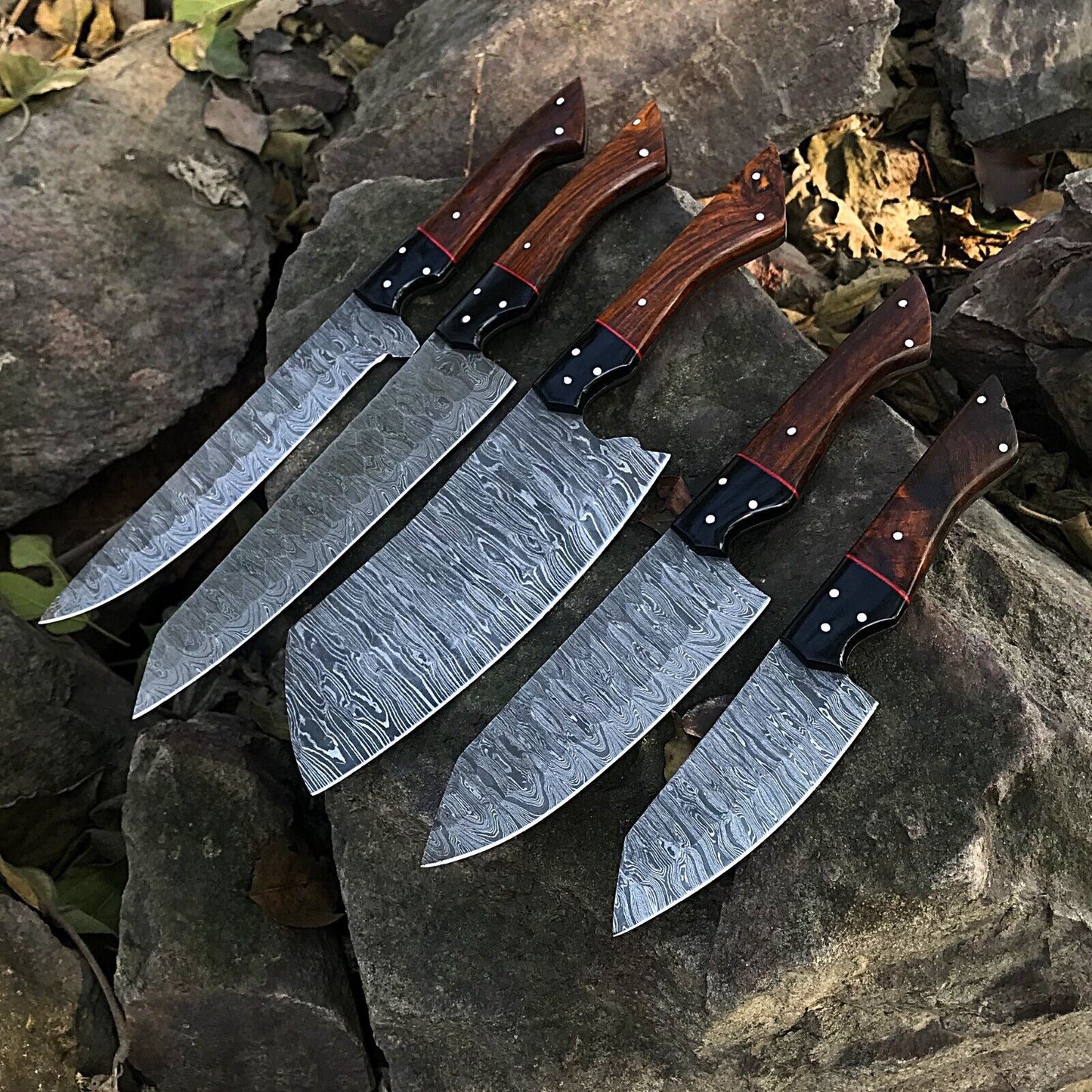 5pc custom handmade Damascus chef knife set featuring forged steel blades and unique handle designs arranged on a wooden surface.