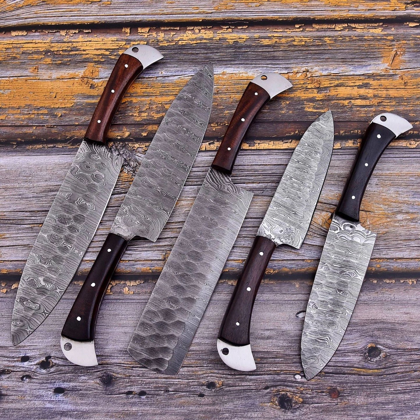 5 pc custom Damascus steel kitchen knife set featuring hand forged blades and ergonomic wood handles with intricate mosaic pin detailing.