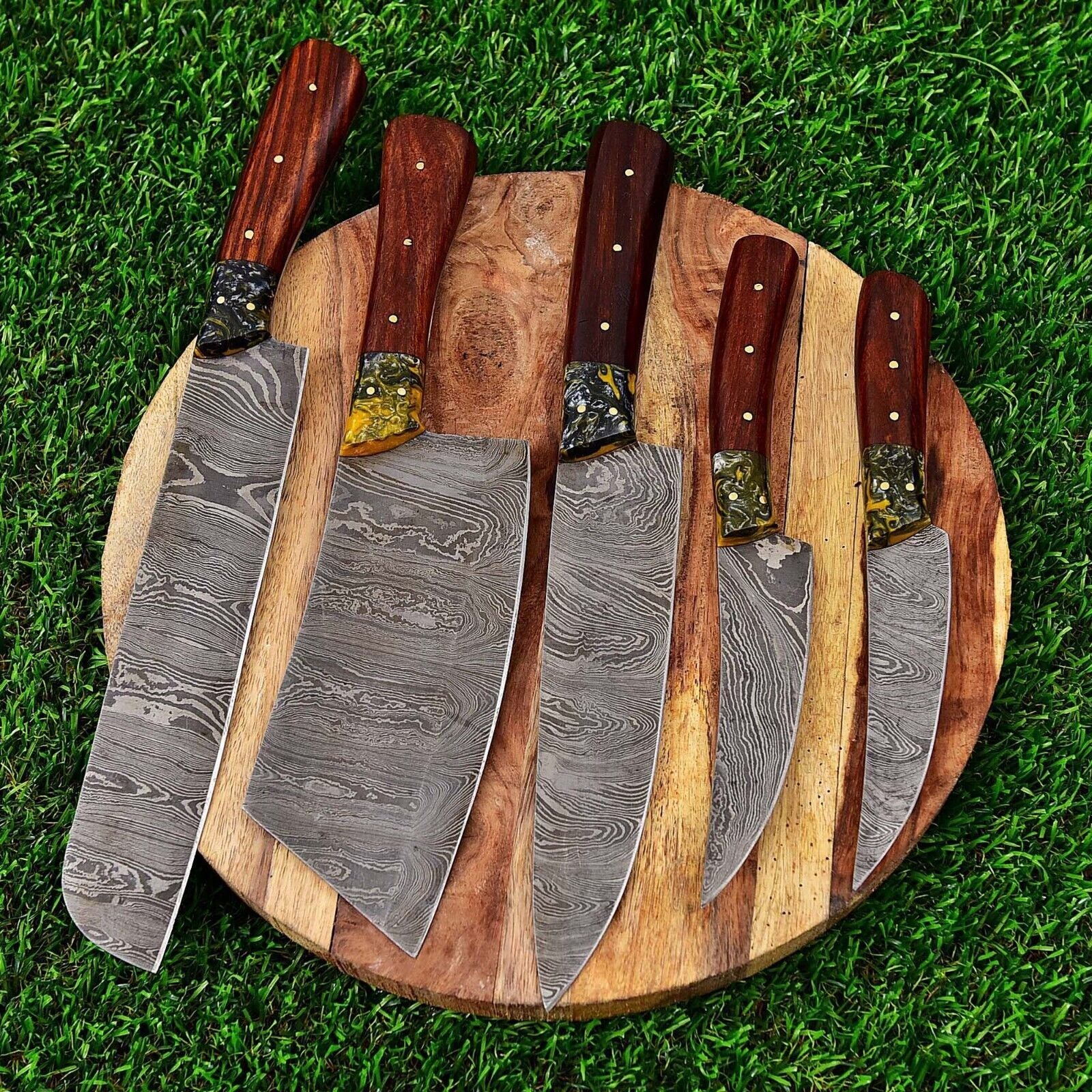 Hand forged 5 pc Damascus steel chef knife set featuring modern wood and acrylic handles, complete with a protective leather sheath.