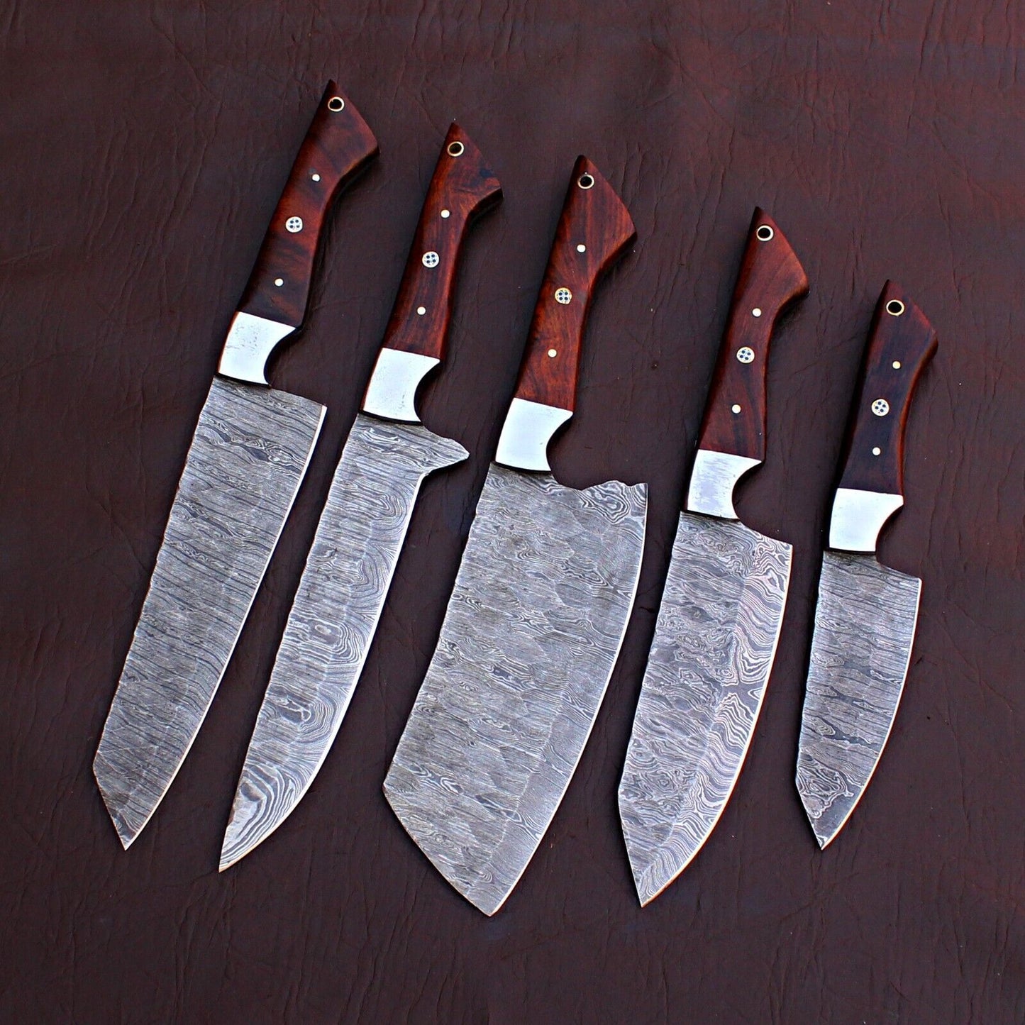 5 pc Damascus steel chef knife set displayed next to a durable leather storage roll for culinary protection.
