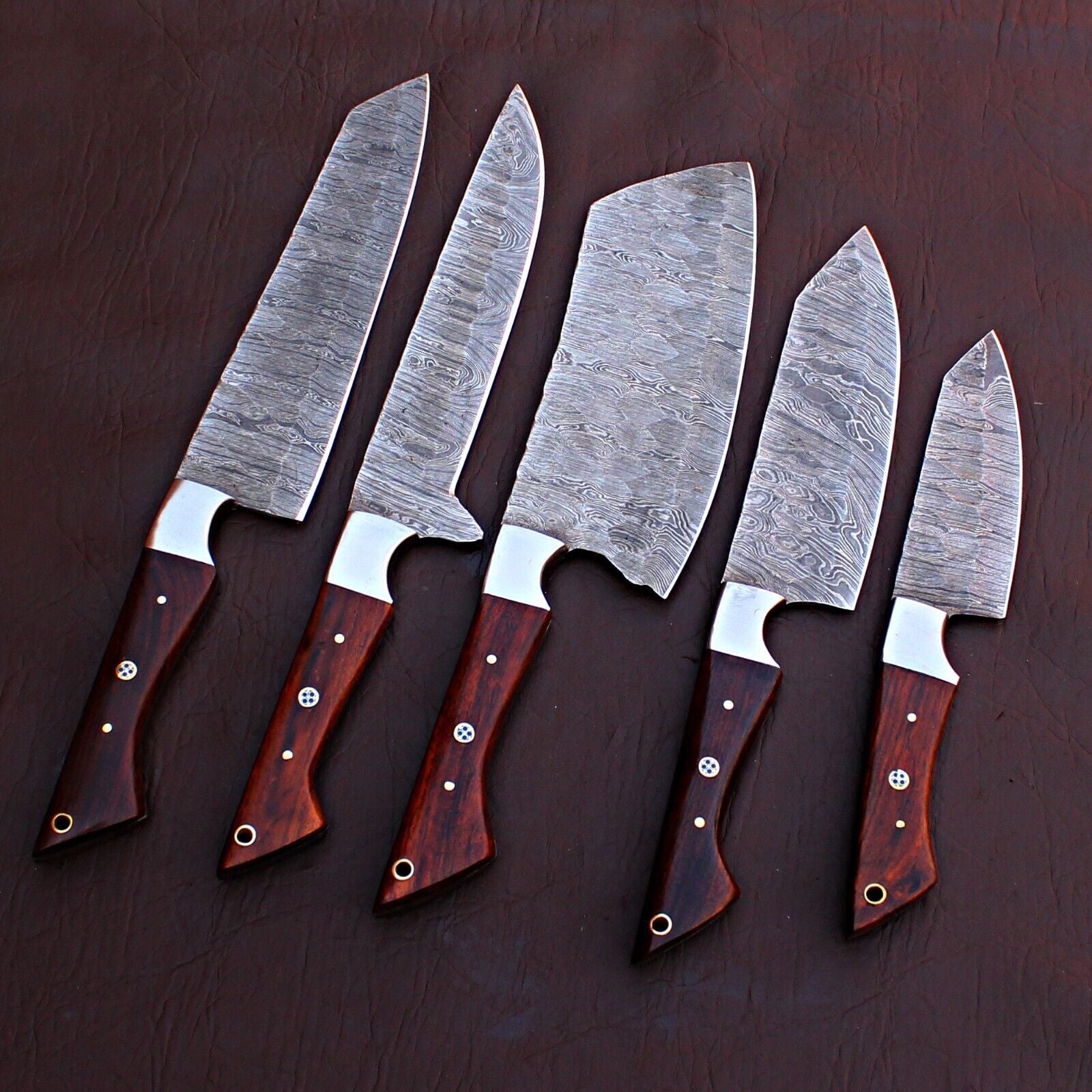 5pc custom handmade Damascus chef knife set featuring forged steel blades and unique custom handles on a rustic wood background.