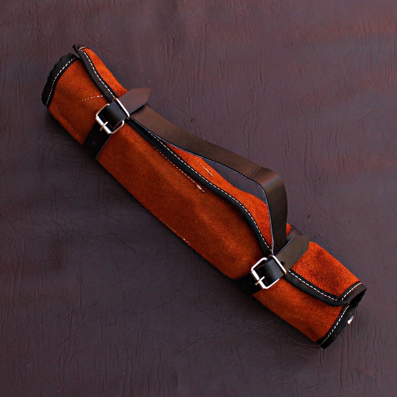 5 pc Damascus steel chef knife set displayed next to a durable leather storage roll for culinary protection.