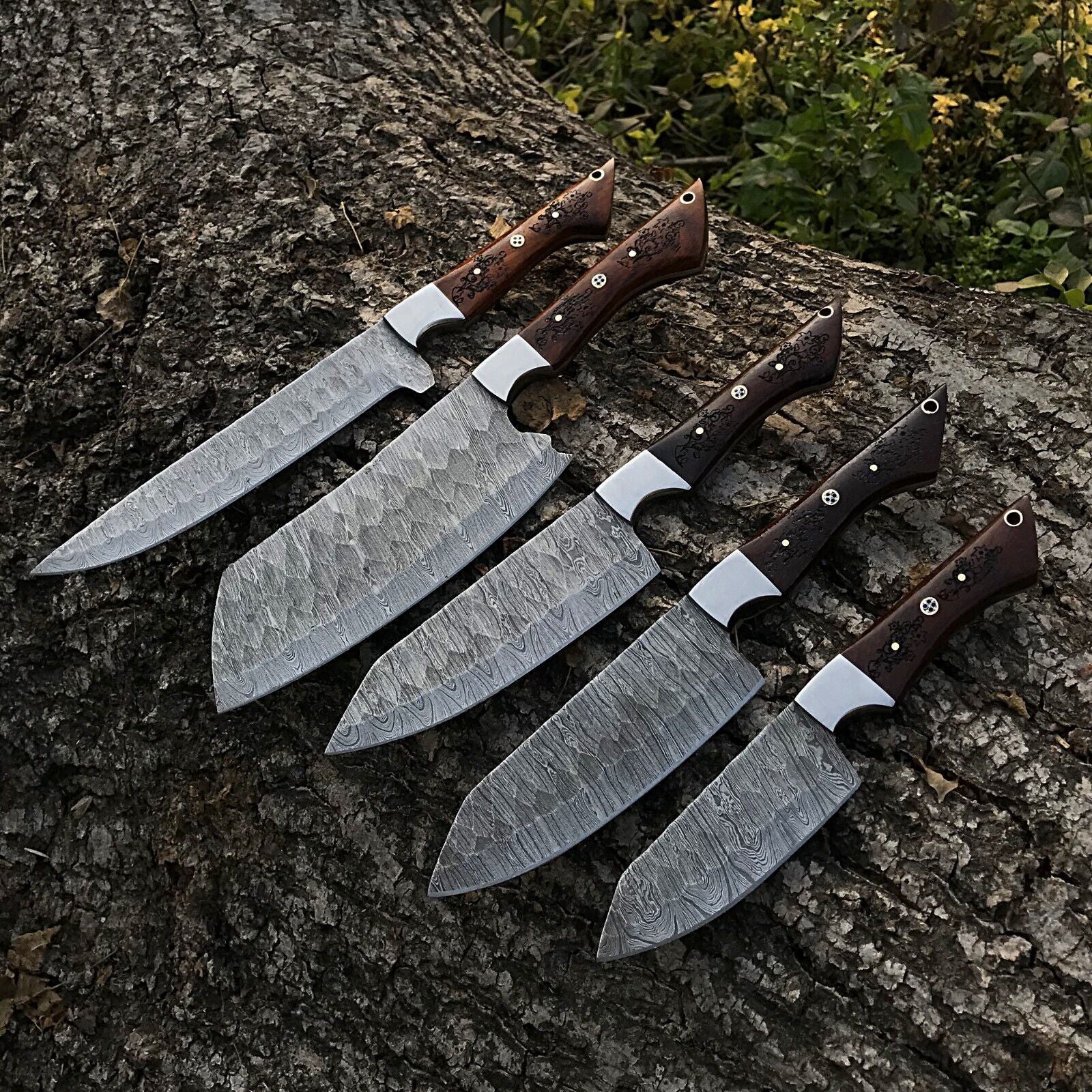 5pc custom handmade Damascus chef knife set featuring forged steel blades and ergonomic handles arranged for display.