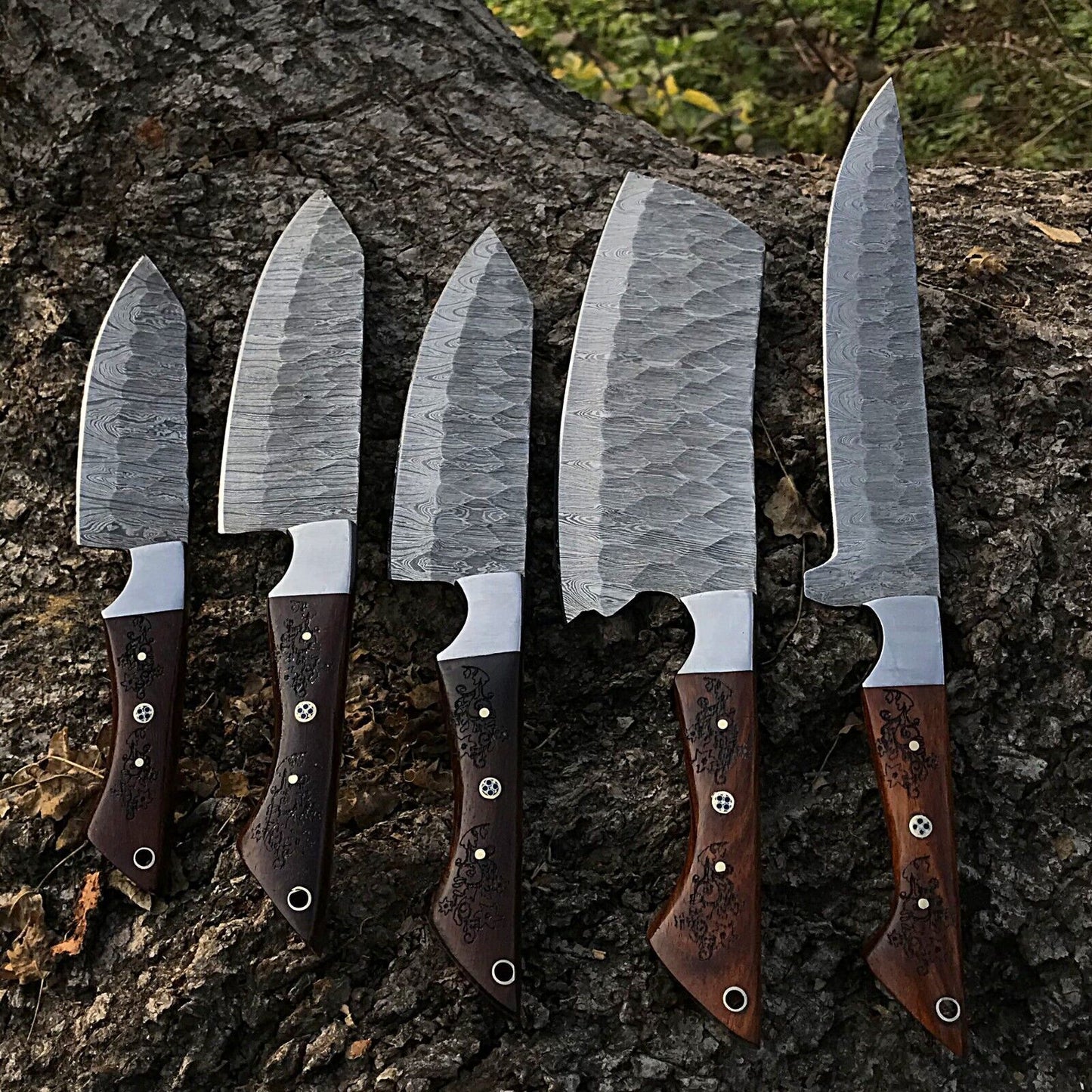 5pc custom handmade Damascus chef knife set featuring forged steel blades and ergonomic handles arranged for display.