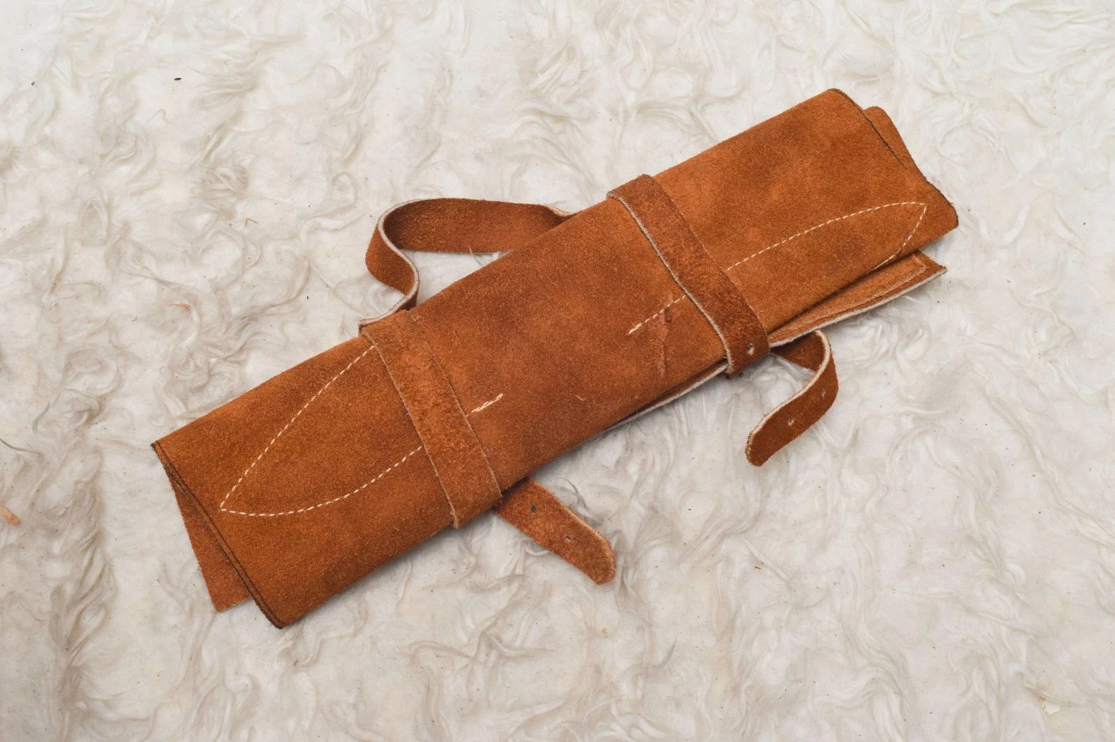 Hand stitched leather roll containing a 5 pc handmade Damascus steel chef knife set for professional kitchen and travel storage