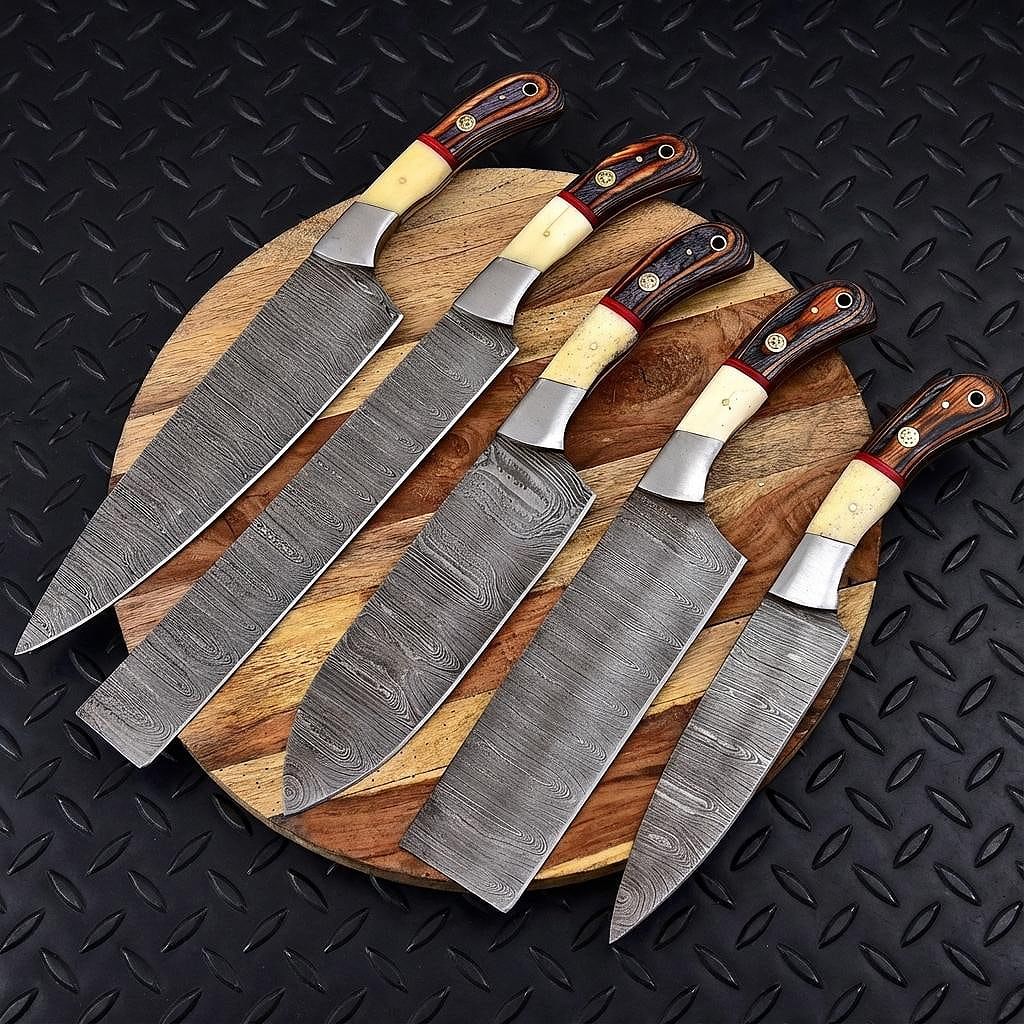 Hand forged 5 piece Damascus steel chef knife set with leather sheath displayed on rustic timber.